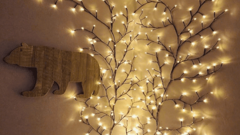 Branch-style lights attached to a wall next to a wooden bear sign