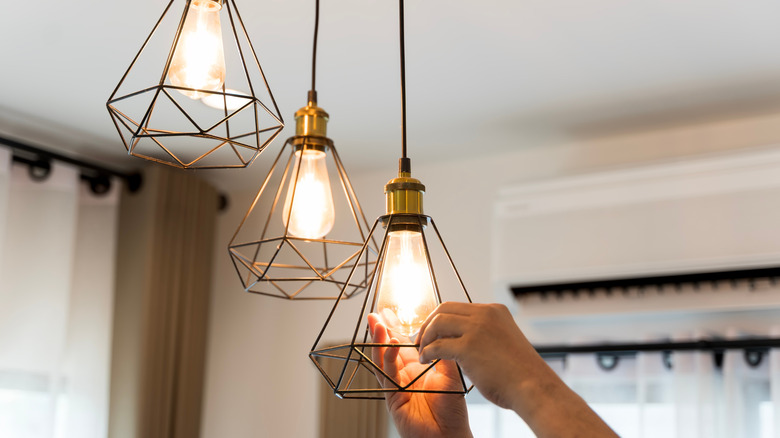 Person replacing light bulbs in a fixture