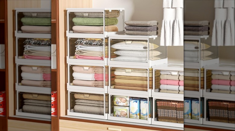 Clear drop front storage boxes stacked up with clothing