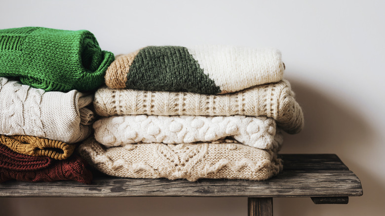Folded sweaters on a shelf