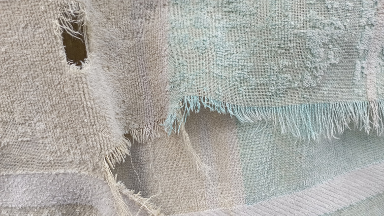 closeup on worn down towel with fraying and holes