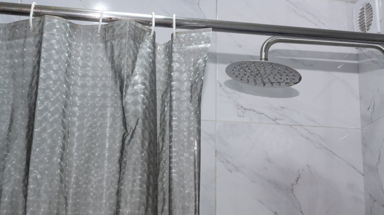 plastic shower liner hanging on a curtain rod