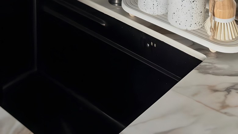 sponge and dispensers on dish beside sink