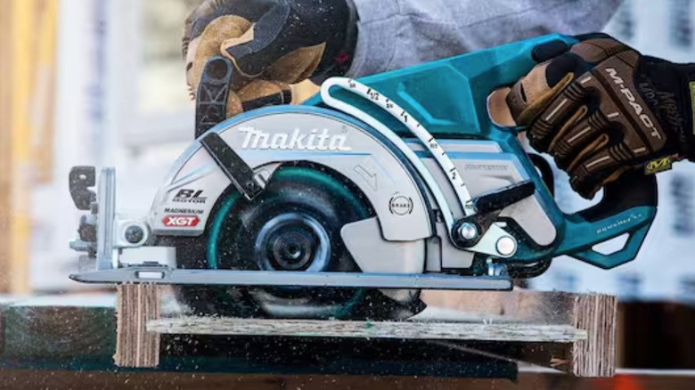 Hands using the Makita GSR01M1 circular saw to cut plywood