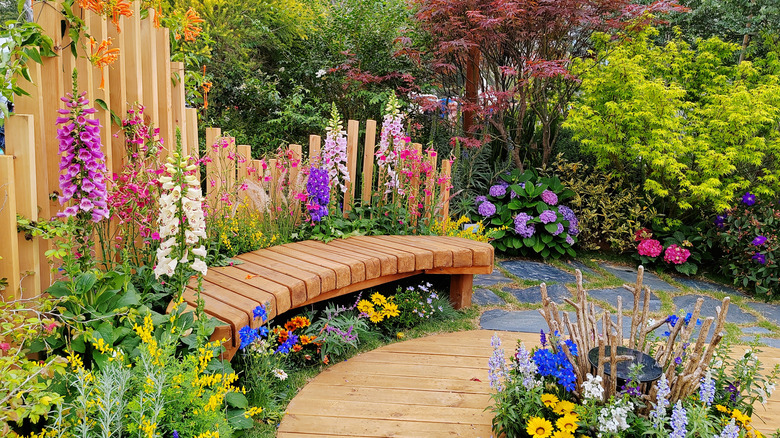 Colorful garden with wooden seating and walkway
