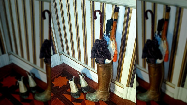 Gold painted rain boot used as umbrella stand