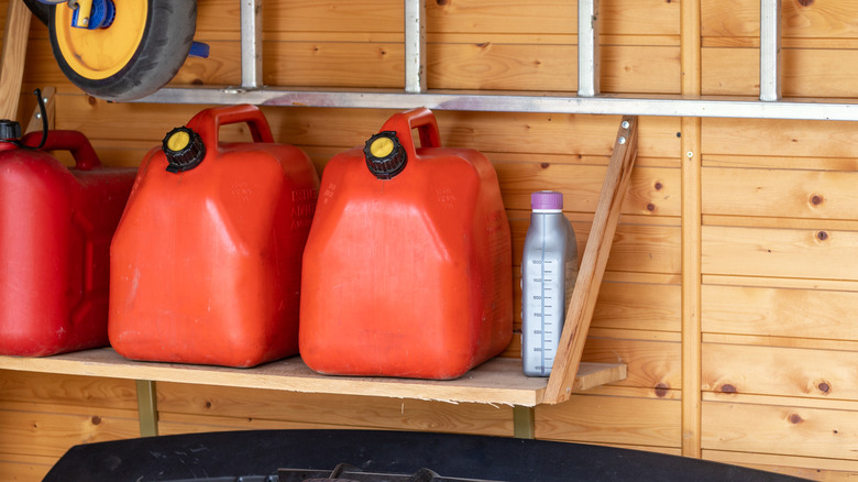 The corner of a garage with gas canisters on a shelf