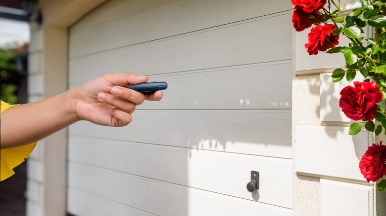 Close-up of a hand testing a garage door with a remote control