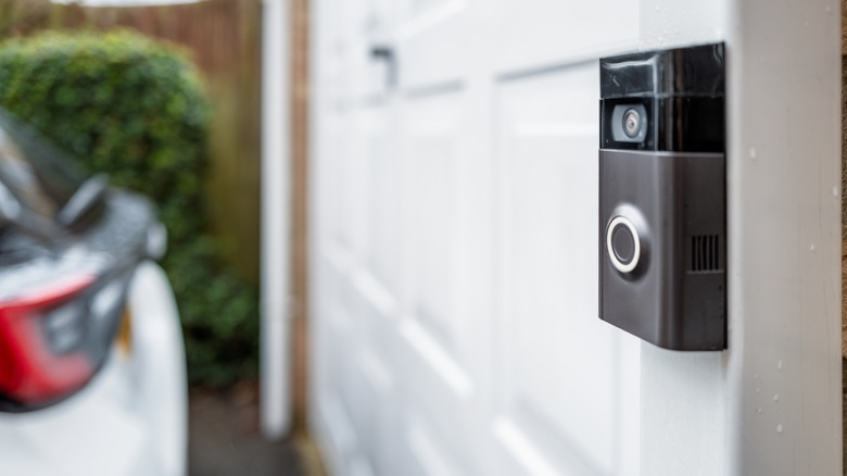 A security camera doorbell system mounted on the side of a garage