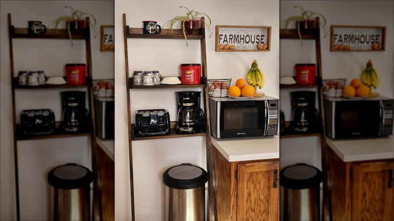 A ladder-style bathroom shelf storing coffee items sits over a trash can