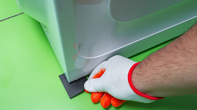 Washing machine with rubber piece under foot
