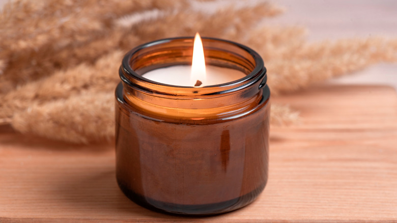 A lit candle in a glass jar