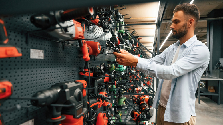 A man browsing power tools in a hardware store