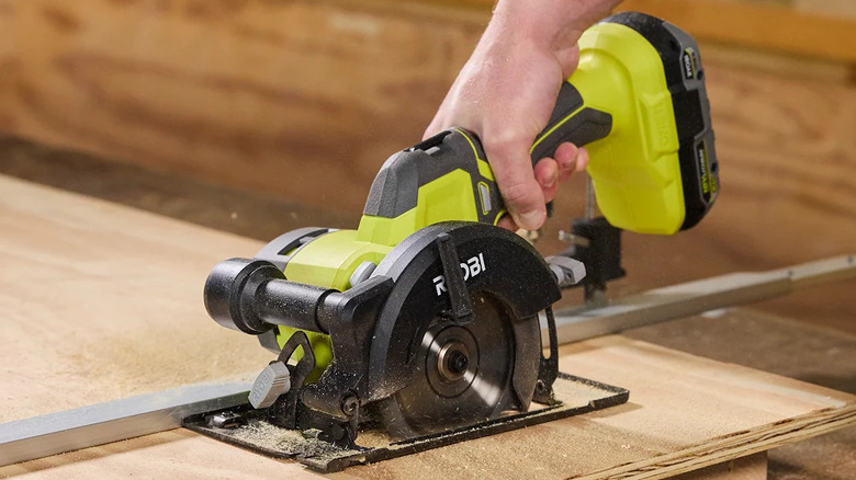 A person cutting wood with Ryobi's 18V One+ 4-½-inch Circular Saw
