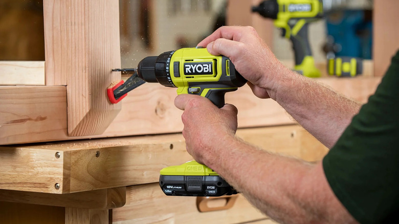 A person using Ryobi's 18V One+ Cordless ½-inch Driver/Drill on a wooden frame