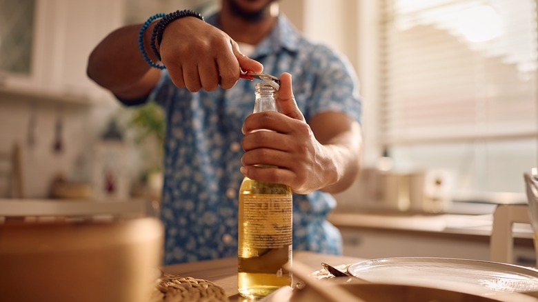 A man opening a bottle of beer