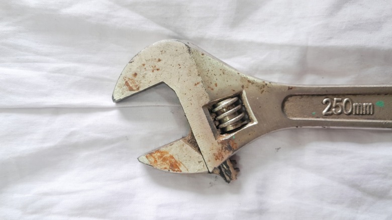 A locking wrench on a white fabric background