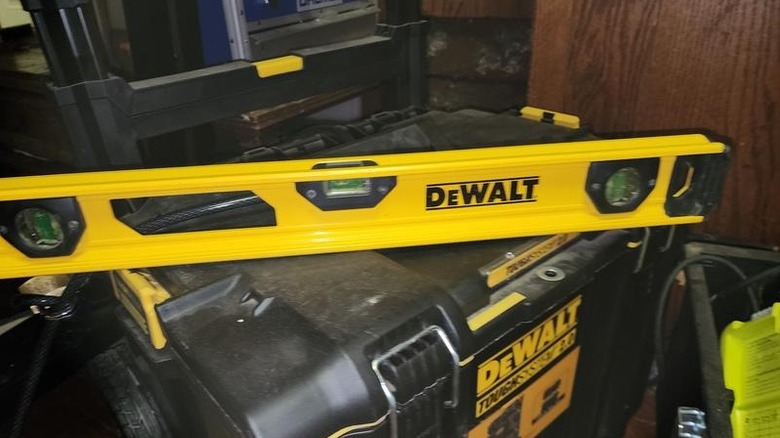Yellow DeWalt I-beam level on top of DeWalt toolbox