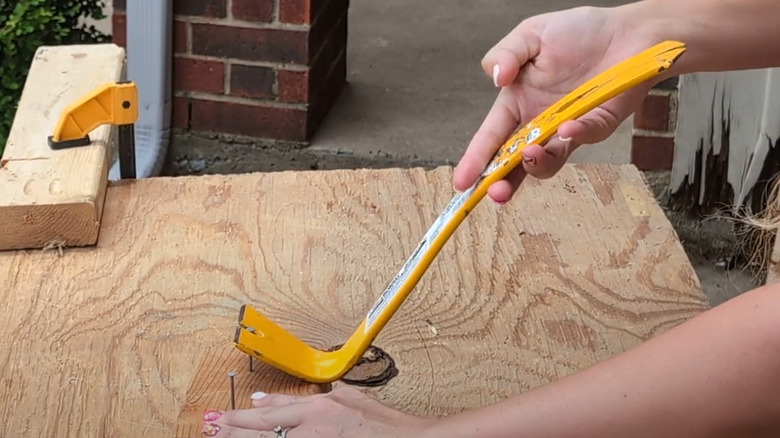 Person using DeWalt pry bar flat bar to pry nails