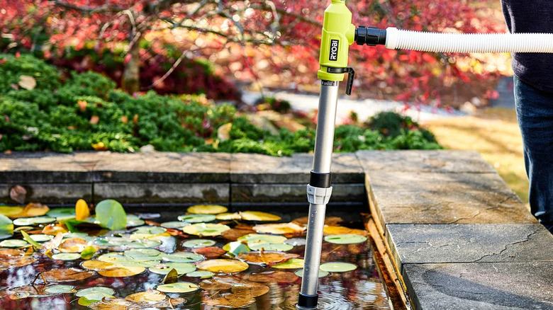 A person emptying a pond with Ryobi's 18V One+ Cordless ⅙ HP Telescoping Pole Pump