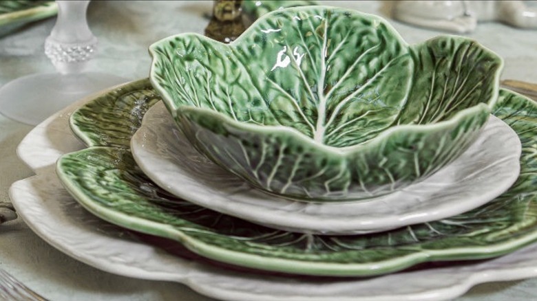 Green and white cabbage shaped ceramic bowls and plates on table