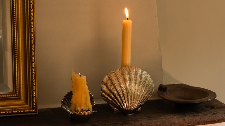Brass Scarlett Candle Holder in seashell shape with two white wax candles and golden portrait frame