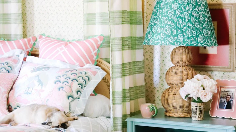 Madcap Cottage Large Rattan Lamp on nightstand with photos, flowers, and decorated bed