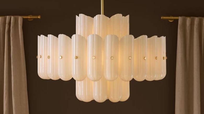 Double Tier LED Chandelier from Rejuvenation hanging from ceiling in front of brown walls and curtains