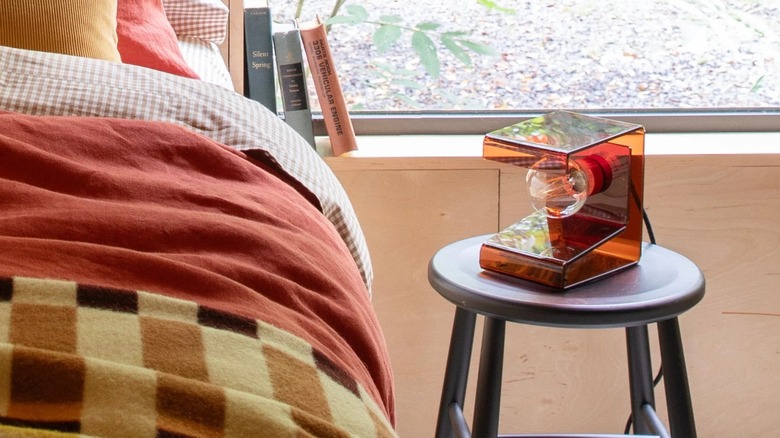 Schoolhouse Pop Light II on bedside stool in front of window