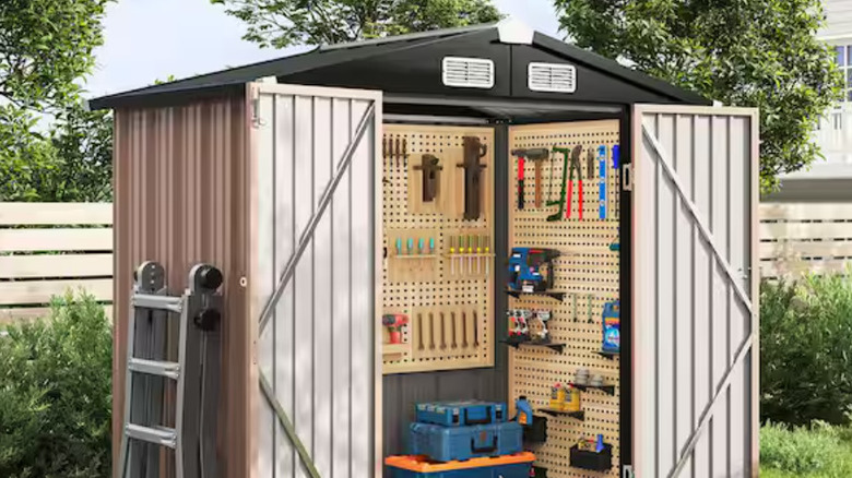 The Sizzim shed with open doors and tools hanging on peg boards.
