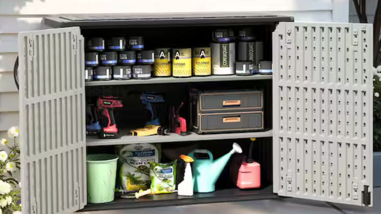 The grey compact Patiowell shed full of gardening supplies.