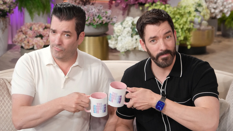 Drew and Jonathan Scott goofing off with cups of tea