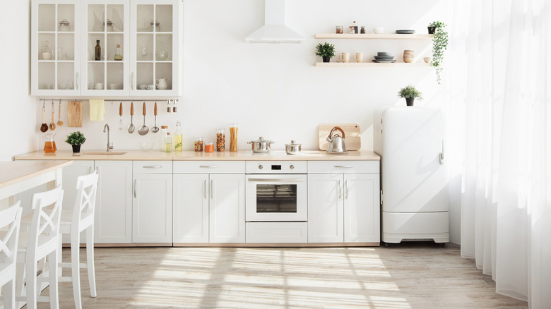 White kitchen with wooden countertops and greenery