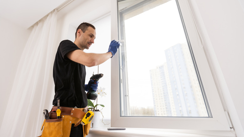 A contractor installs an energy-efficient window into a house.