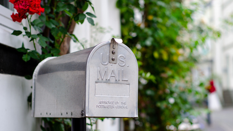 A metal U.S. Mail mailbox outside a home.