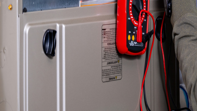 Using a meter to check a broken furnace