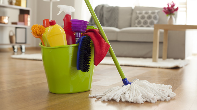 A plastic bucket filled with cleaning supplies in a home