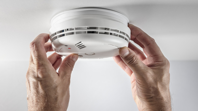 Picture of hands testing smoke detector function