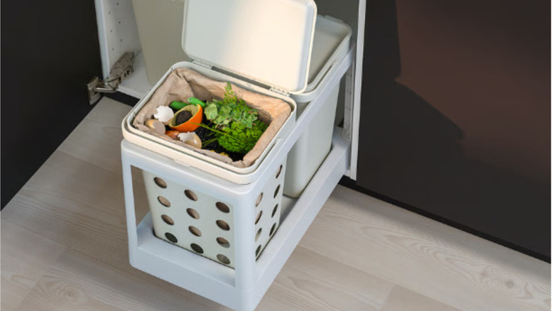 Ikea's pull-out garbage system is shown extending from a kitchen cabinet