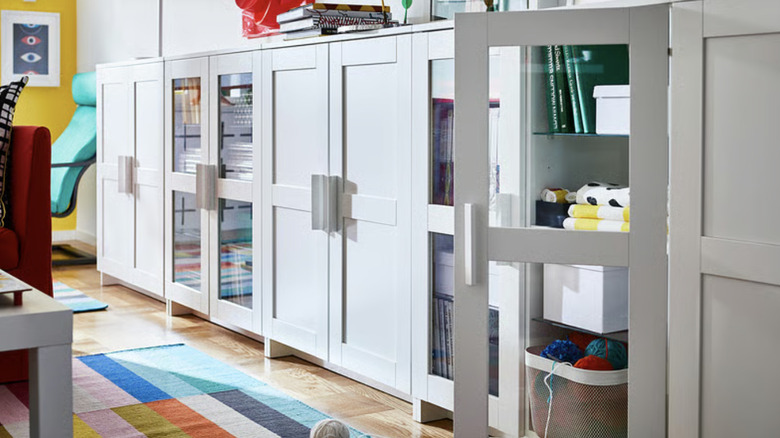 A collection IKEA BRIMNES cabinets with doors along a wall