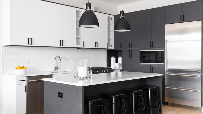 A kitchen with minimal black pendant lights