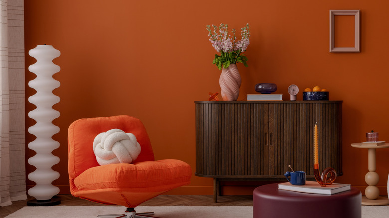 A living room with an orange accent wall