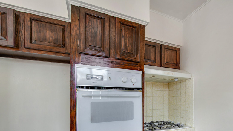 A kitchen with dark brown standard overlay wood cabinets