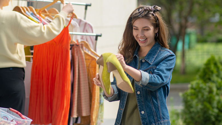 Woman smiling while holding high heels at a garage sale