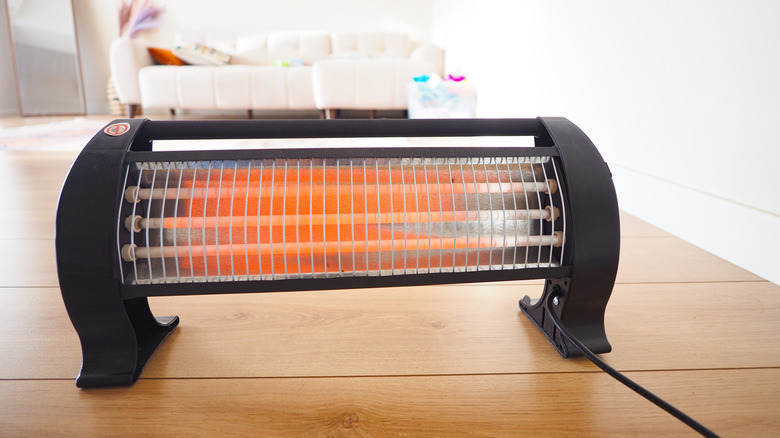 Indoor space heater on floor with sofa in background