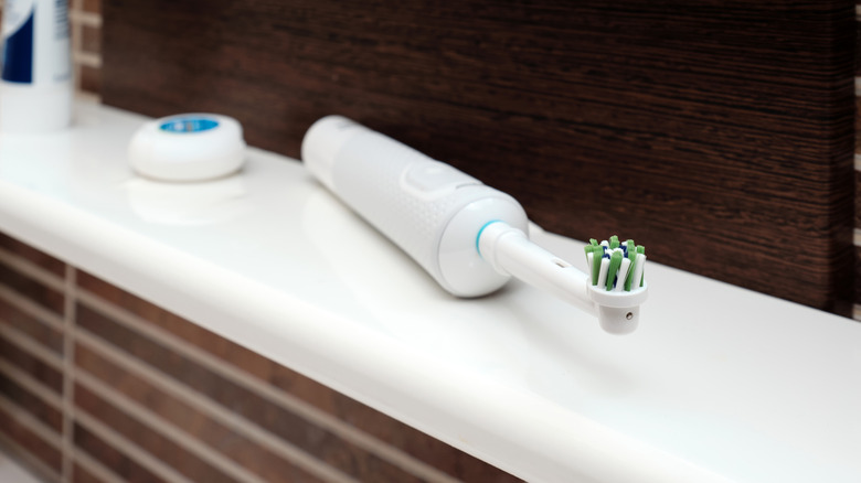 Electric toothbrush on white bathroom counter