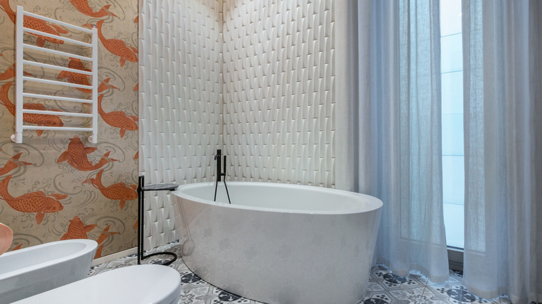 A bathroom with bold fish wallpaper.