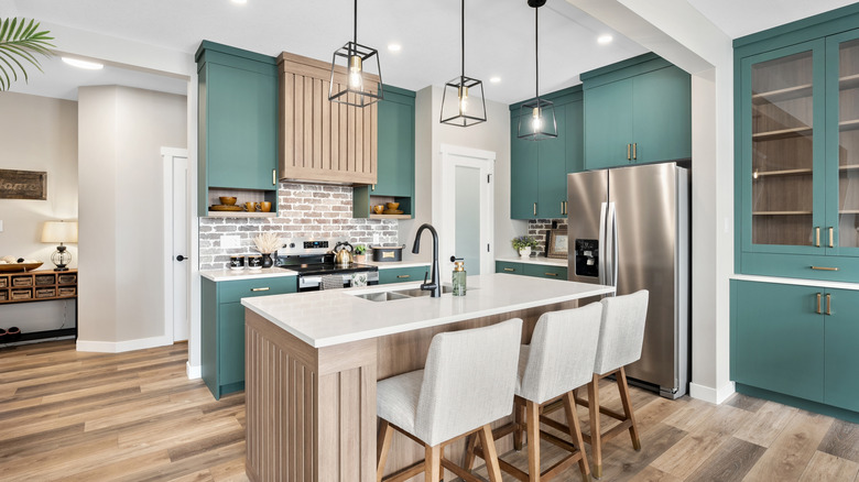 Blue green kitchen cabinets in a light and bright kitchen