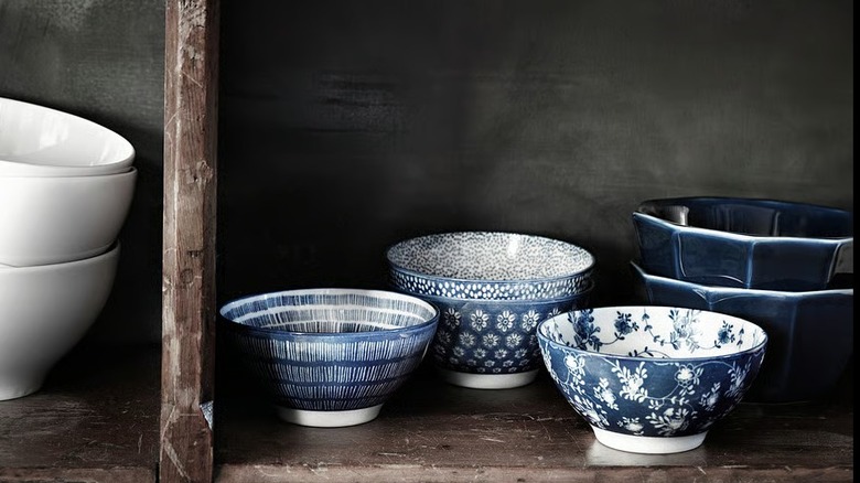 Distinct patterned blue bowls in a wood shelf