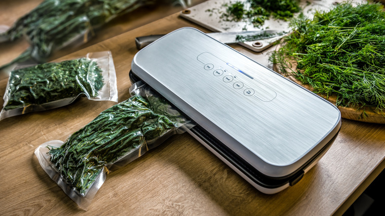 vacuum sealer being used to preserve dill